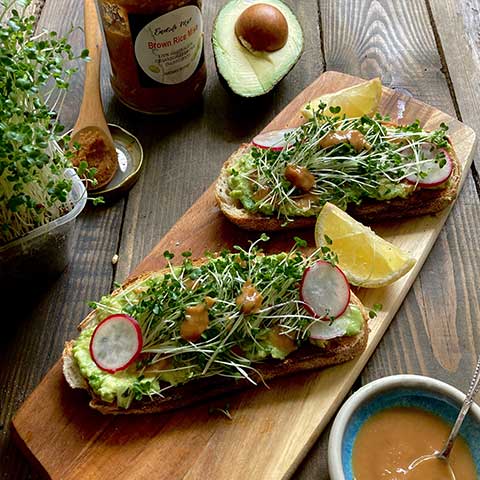 Smashed avocado and broccoli sprouts on toast with miso sauce