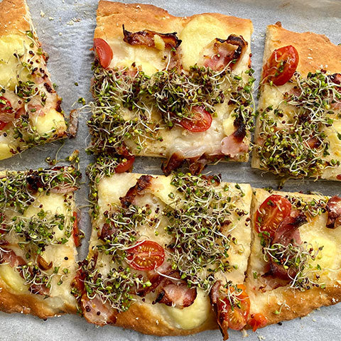 Prosciutto and cherry tomato pizza with broccoli sprouts
